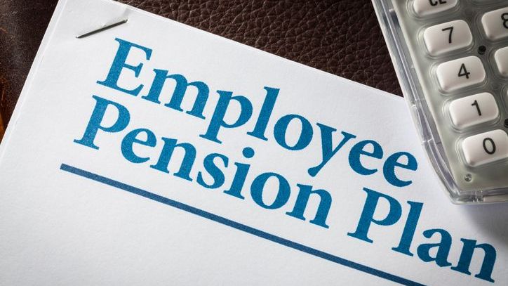 An employee pension plan on a note pad with a calculator.