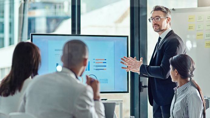 A business owner delivers a pitch in front of an angel investor and his team.