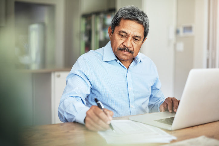 A man reviewing the benefits and drawbacks of a deferred compensation plan.