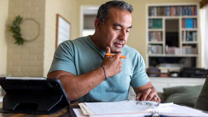 A man does math on a calculator.