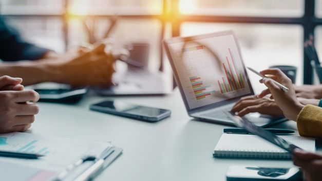 An advisor showing an investment plan to clients at an office table.