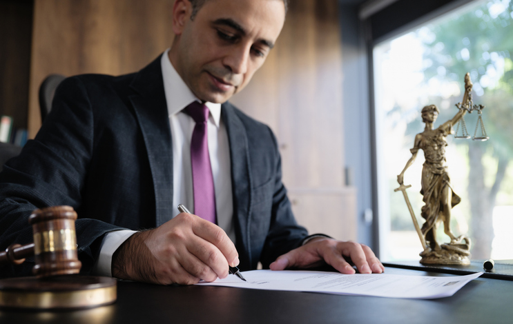 A lawyer fills out paperwork in their office.