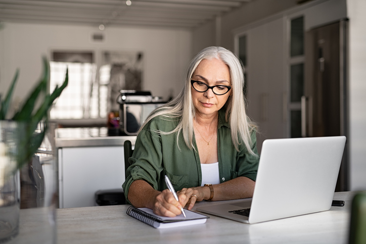 A woman calculating how much she will have to withdraw from her 401(k) as a required minimum distribution.