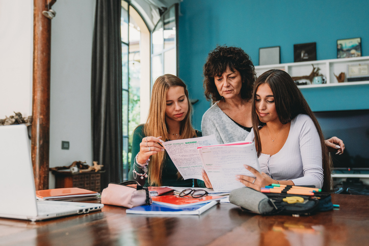 A parent reviewing FAFSA documents with her children.