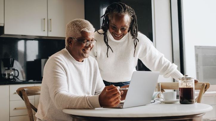 A mature couple researching their retirement options together at home.