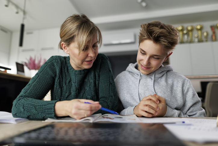 A mother and her teenage son review an investment portfolio.