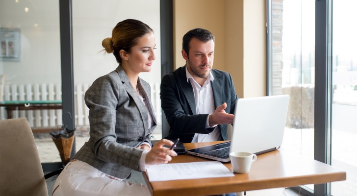 Two investors tracking stock in a portfolio.