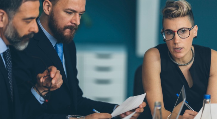 A financial advisor discussing corporate tax rates with clients.