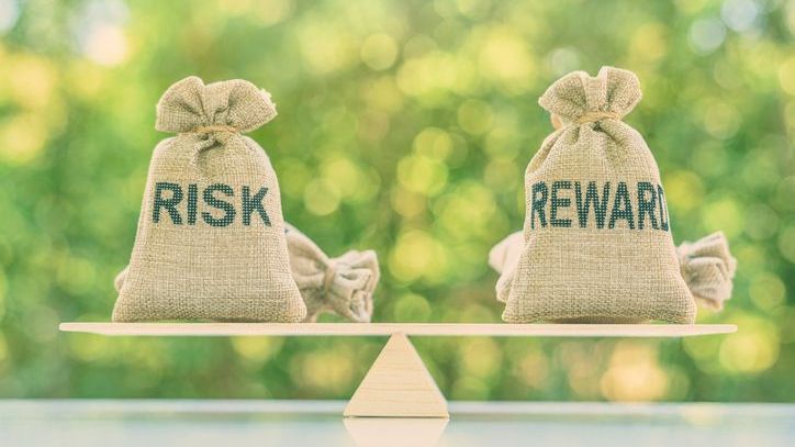 Risk and reward bags on a basic balance scale in equal position.