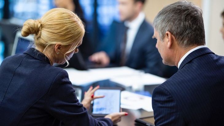 A group of businesspeople sitting at a conference table having meeting.