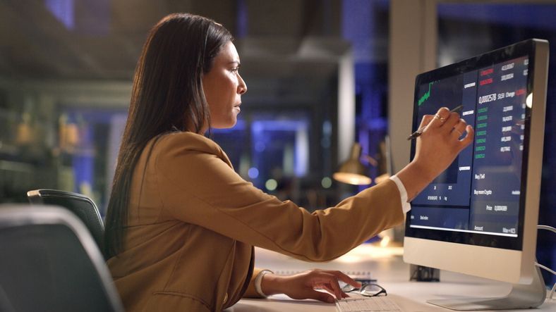 A trader looks at financial data on her computer screen in her office.