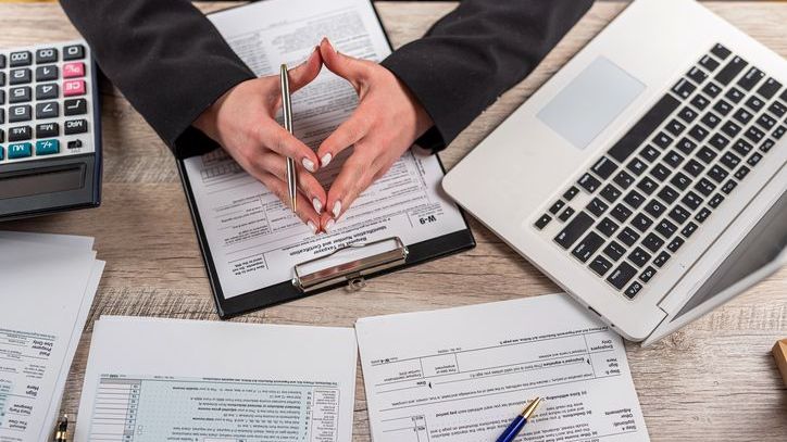 A woman working on tax forms at her desk.