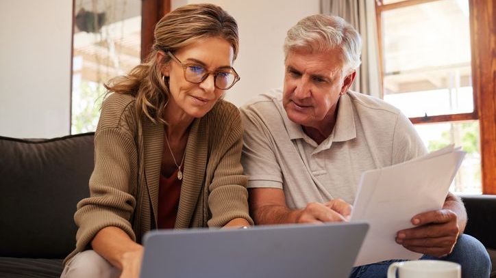 A couple review their retirement budget together on a laptop computer.