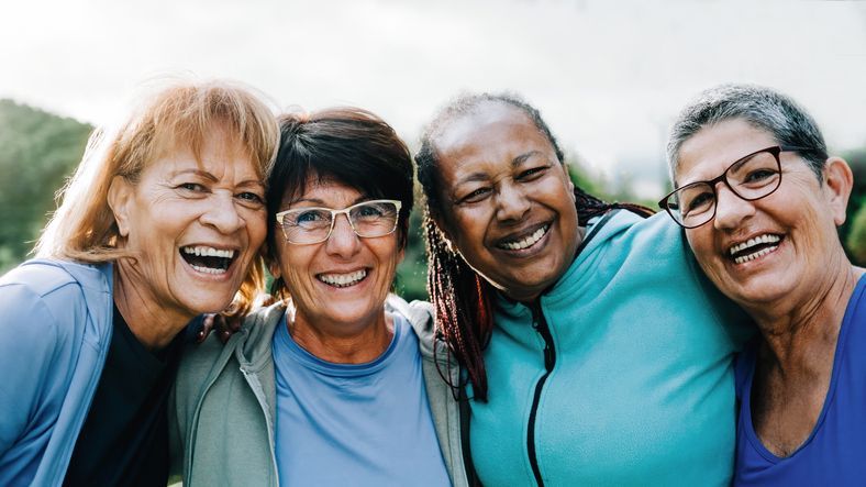 Senior women smile while exercising together.