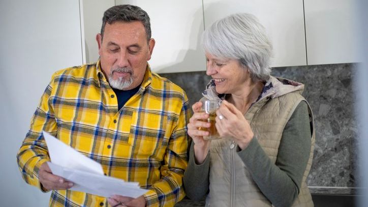 A couple looks over documents in their kitchen.
