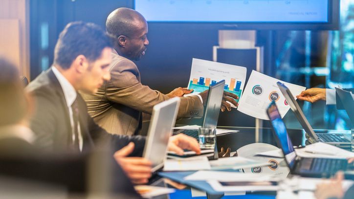 Colleagues review charts and data together.