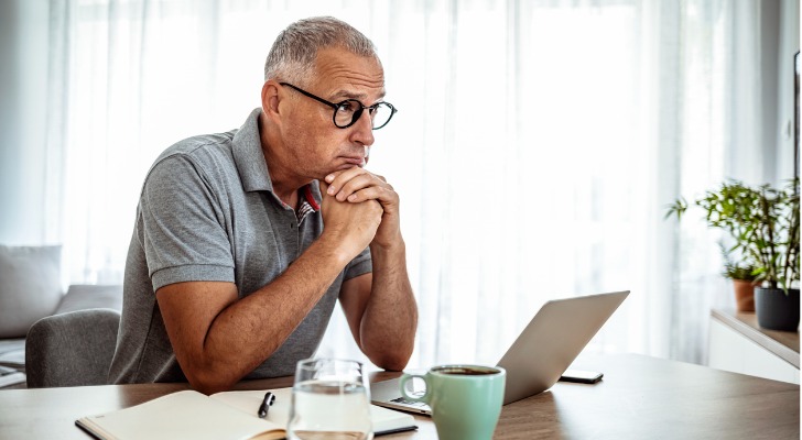 A man close to retirement calculating how much he needs to save.