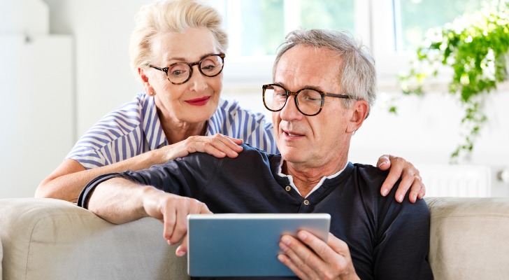 A senior couple reviewing investments for their retirement portfolio on a tablet.