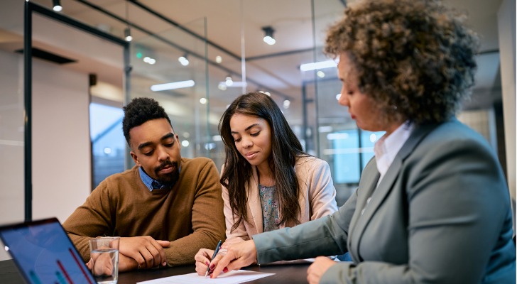 A couple meets with a financial advisor to set up retirement savings goals for their portfolio.
