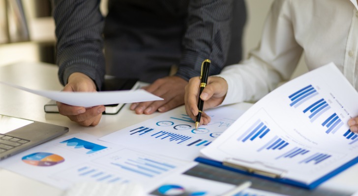 Financial advisors reviewing data to develop a quarterly newsletter strategy.