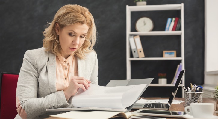 A financial advisor reading notes from a coach.