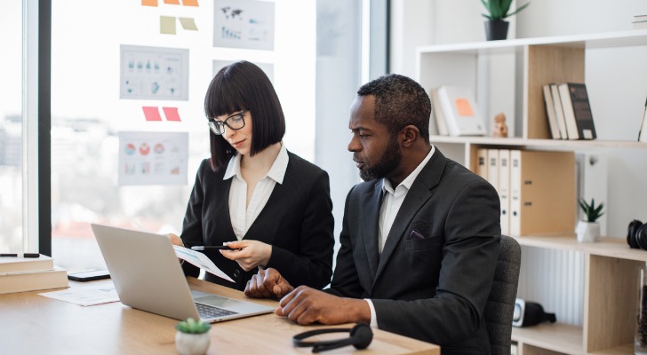 Financial advisors evaluating Nasdaq and S&P 500 investments for clients.