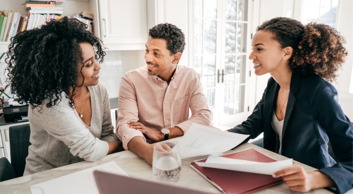 A couple meet with their advisor to discuss stock and bond allocations by age.