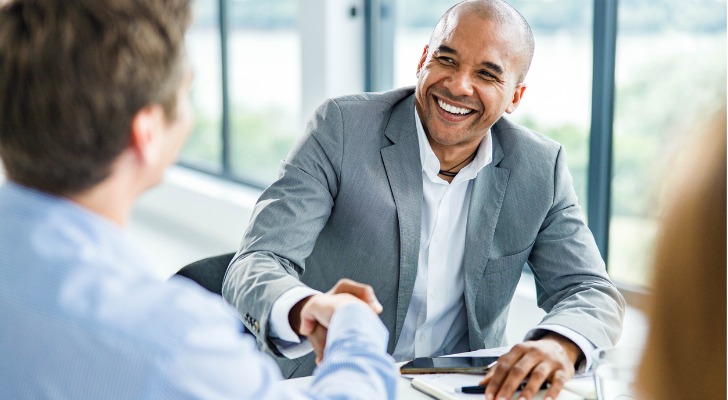 A financial advisor meeting with clients to review a plan.