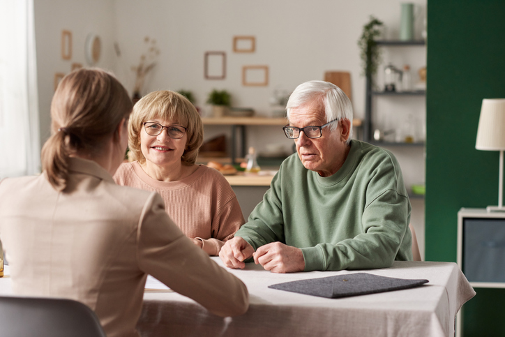 A senior couple rebalancing their retirement portfolio with an advisor.