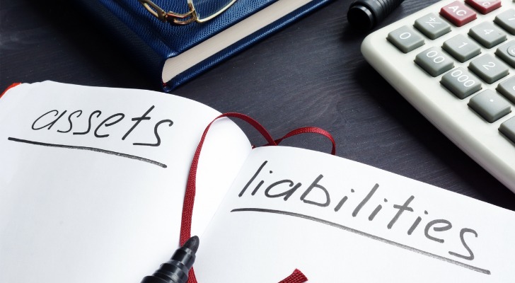 Closeup of a notebook comparing assets and liabilities.