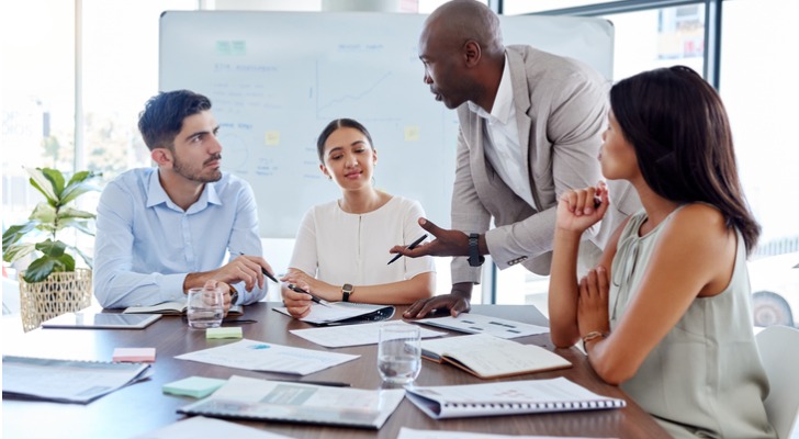 Financial advisors discussing a quarterly newsletter for their firm.
