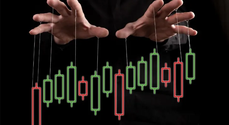 A hand over a stock chart.