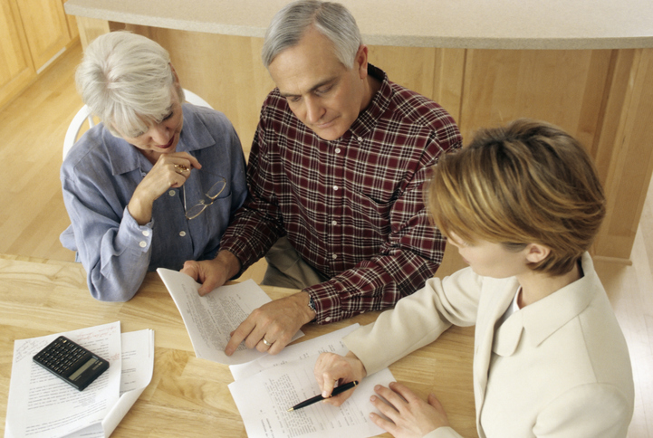 A senior couple discussing a living trust with a financial advisor.