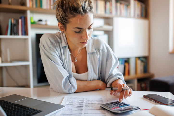 A woman calculating a tax rebate.