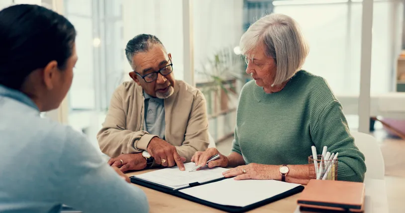 A senior couple reviews a will with a financial advisor.