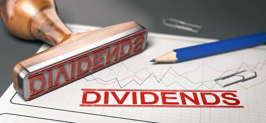Rubber stamp with the word "DIVIDENDS" printed over a stock chart.